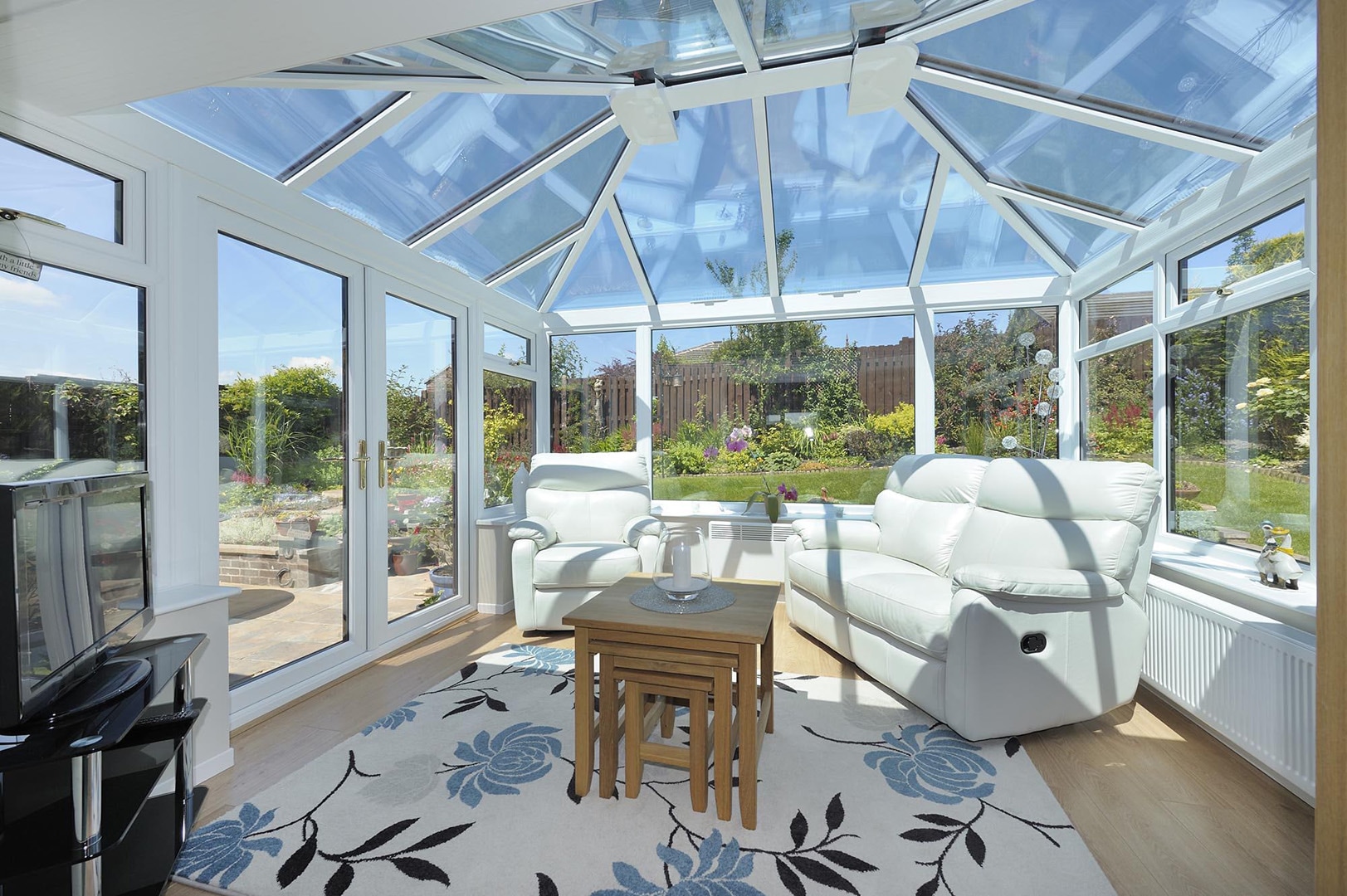 Modern conservatory upgrade featuring sleek glass panels and contemporary design elements, integrated with a traditional home to create a harmonious blend of old and new architectural styles.