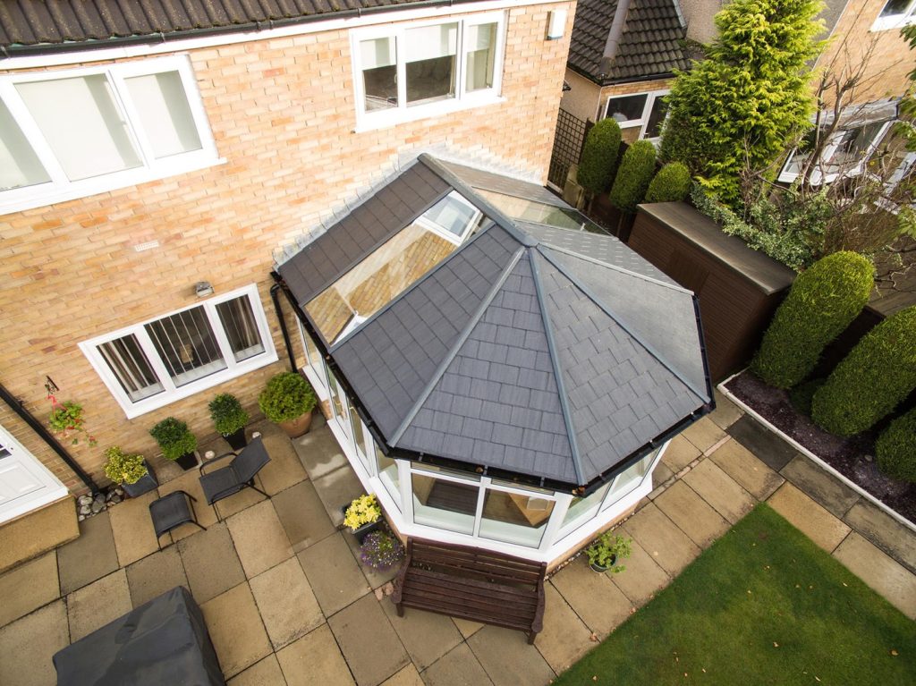 a top down view of a modern victorian shaped conservatory with a tiled roof and velux windows in the roof.