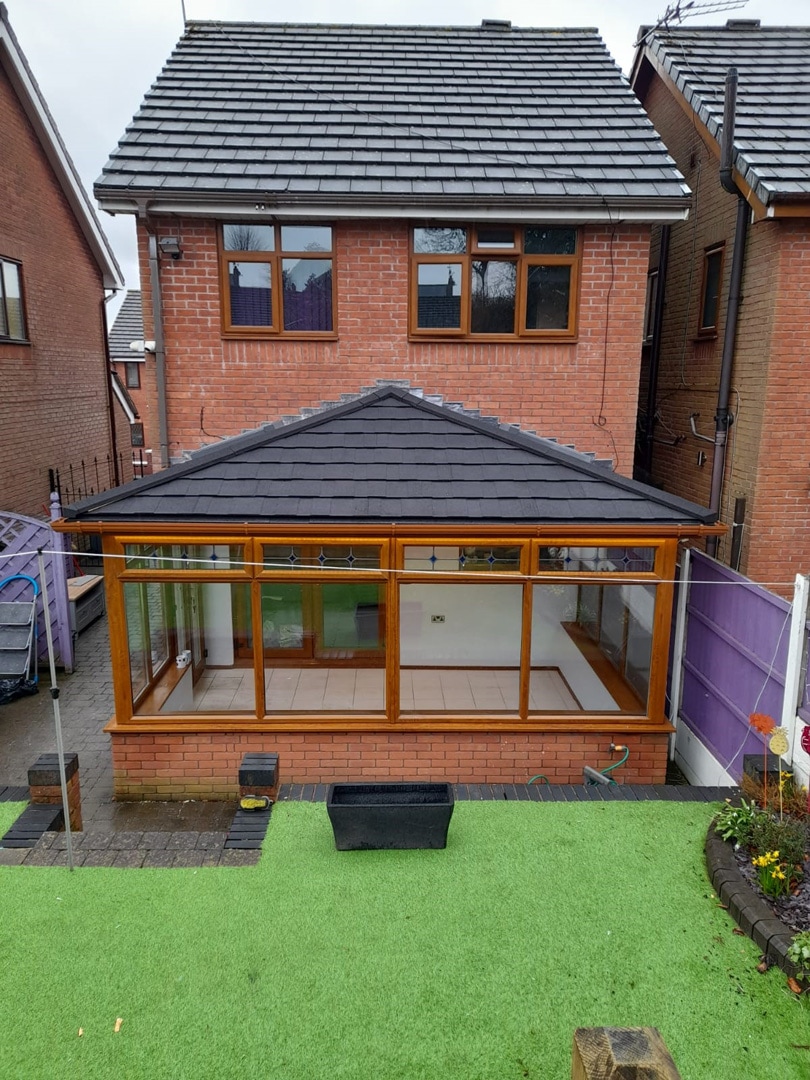 Elegant conservatory with a new tiled roof, seamlessly integrating with the existing structure, providing a stylish and practical upgrade that enhances both the appearance and insulation of the space