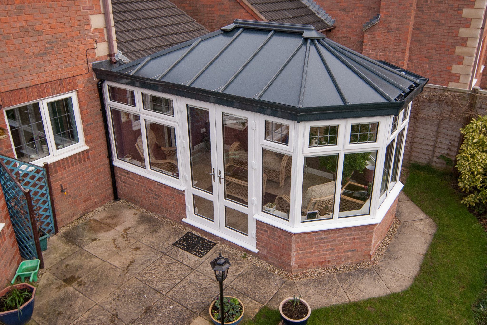 Victorian conservatory style built onto a red brick house.