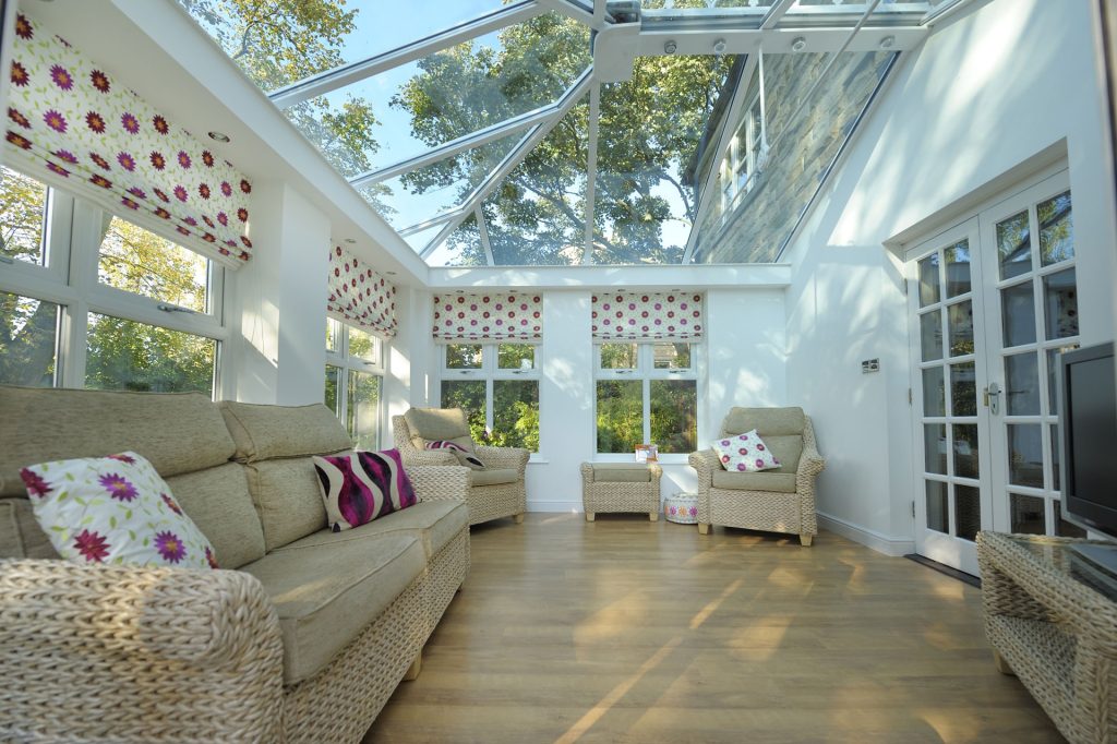 Georgian style conservartory with glass roof and french doors leading into the house.