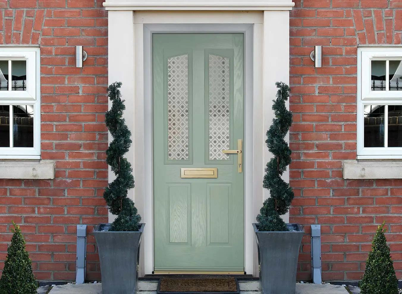 teal coloured composite door with plants on either side of the door.