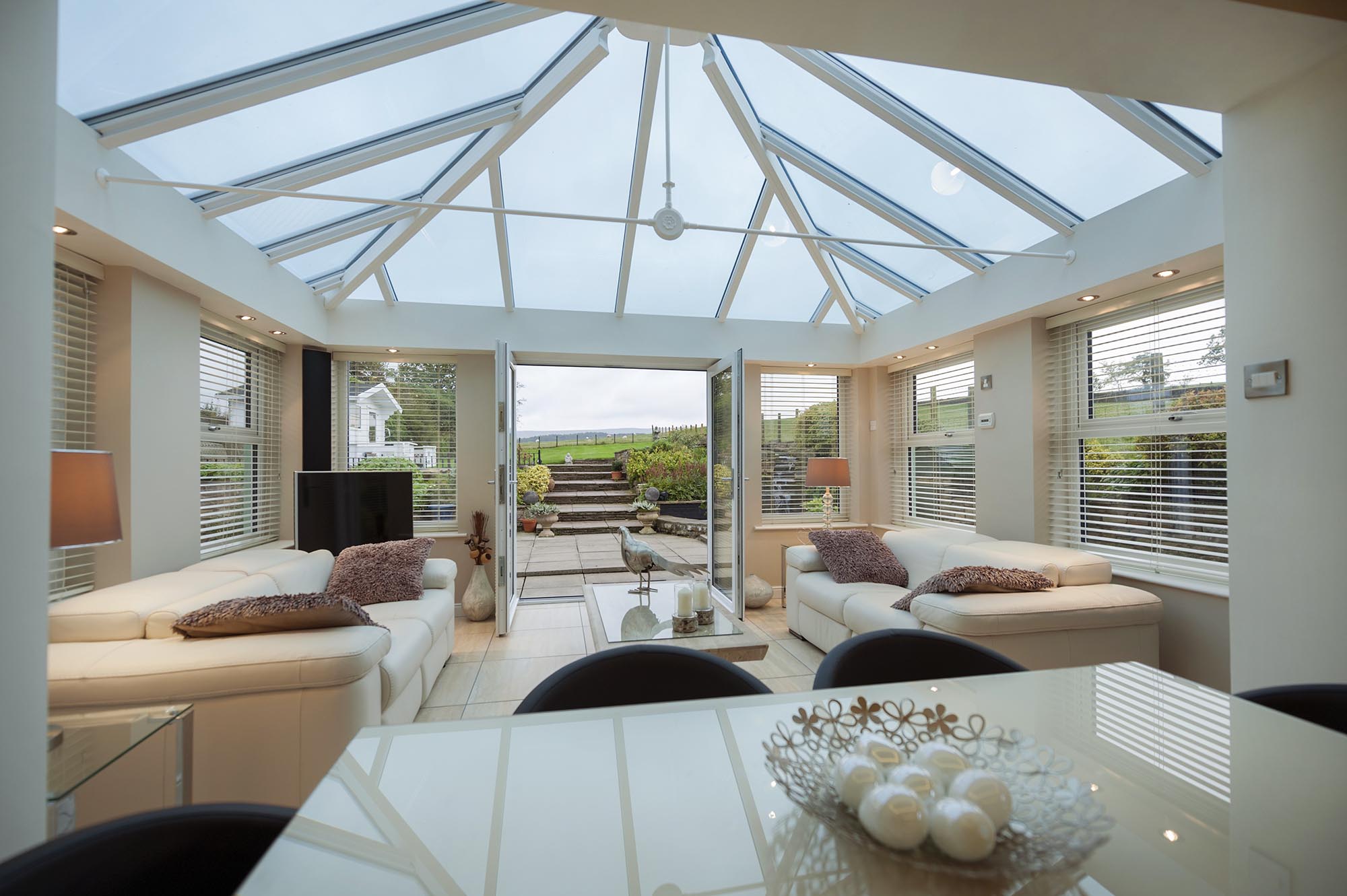 Spacious double-glazed modern conservatory featuring expansive glass panels and a clean, contemporary design, emphasizing brightness and open living space.