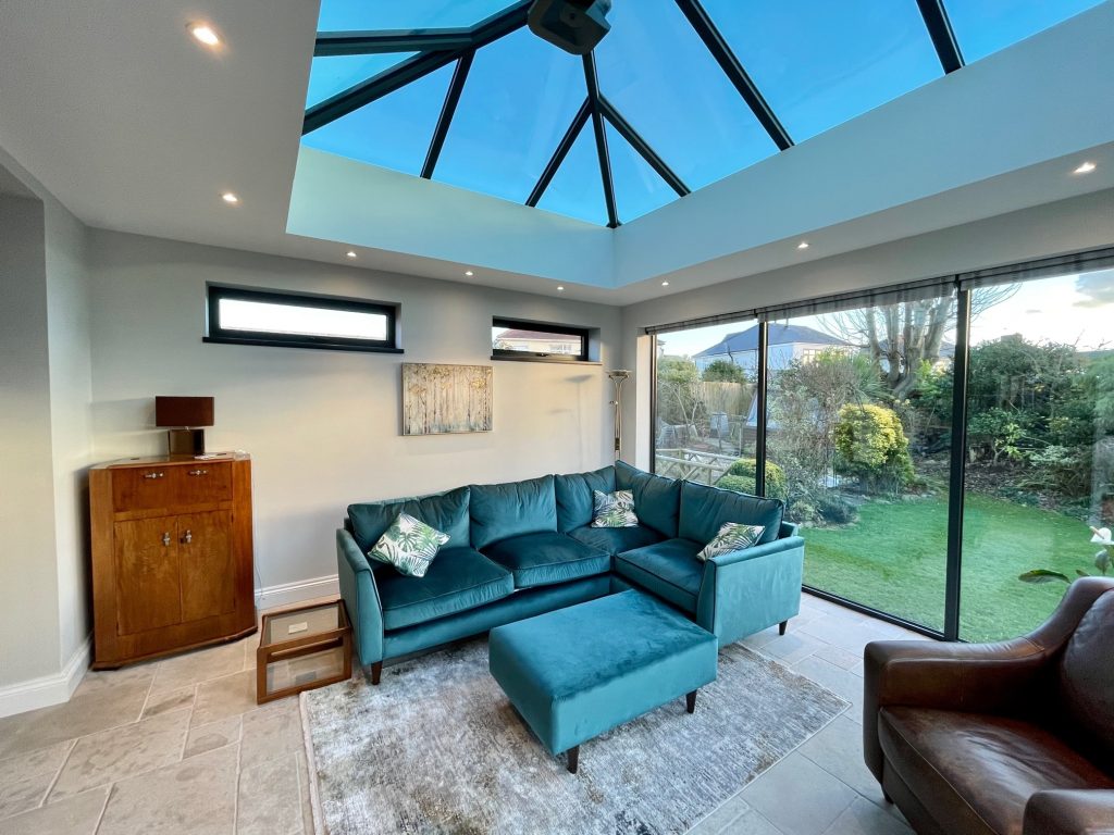 Interior view of a conservatory showing a detailed internal pelmet, adding a refined touch to the ceiling, complemented by elegant lighting fixtures, enhancing the room's ambiance