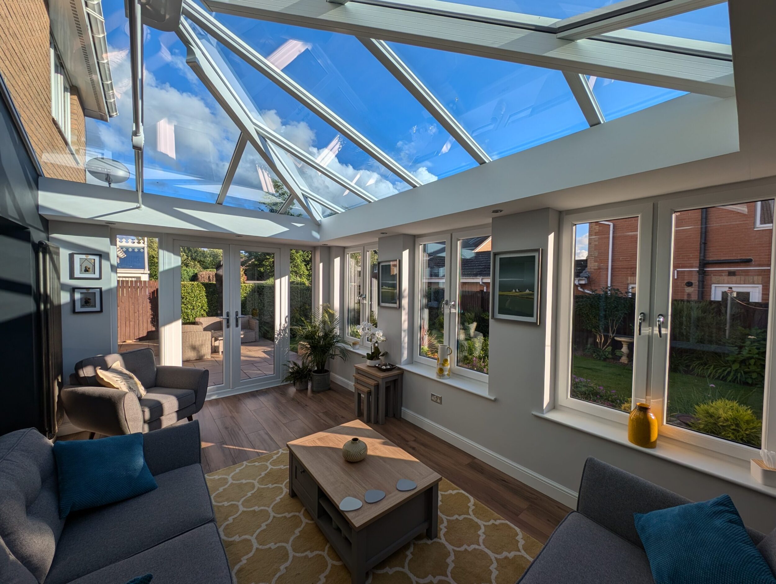 inside looking out of a modern orangery extension with an elegant white roof