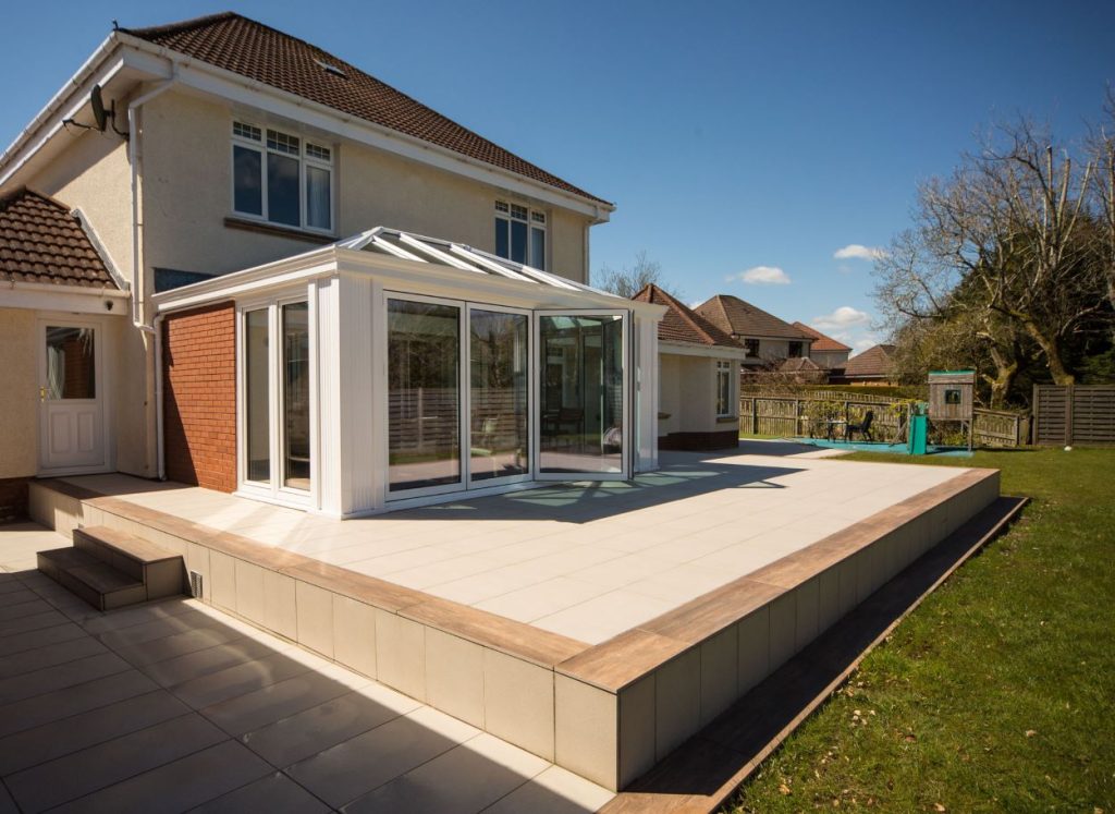 orangery on raised patio area in back garden with open bifold doors