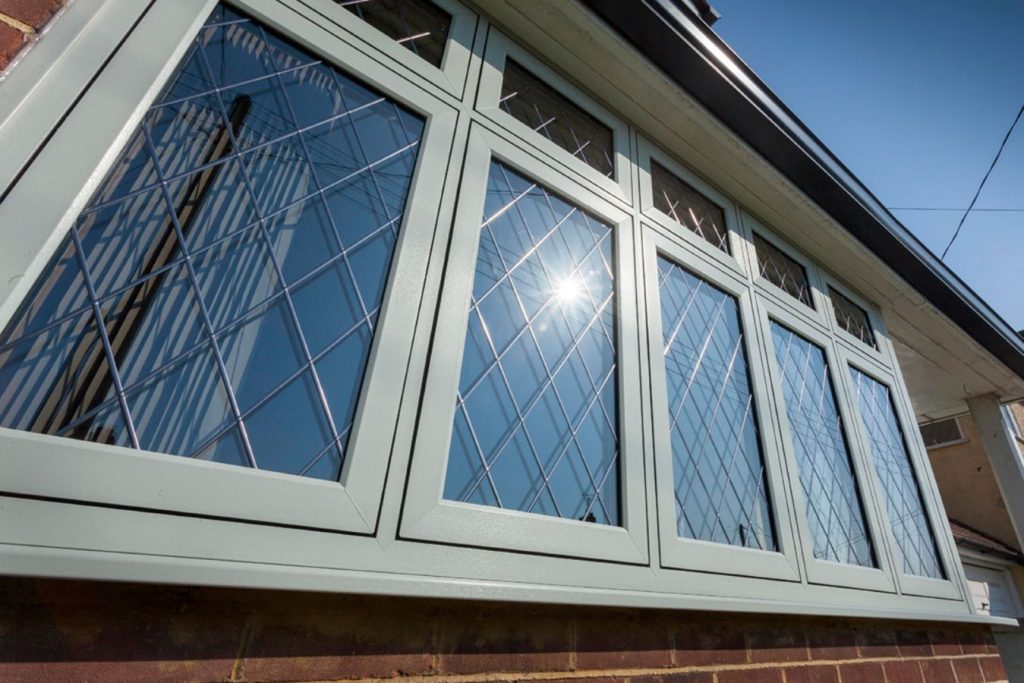 close-up of white upvc flush casement windows, with sun shining and reflecting off the glass