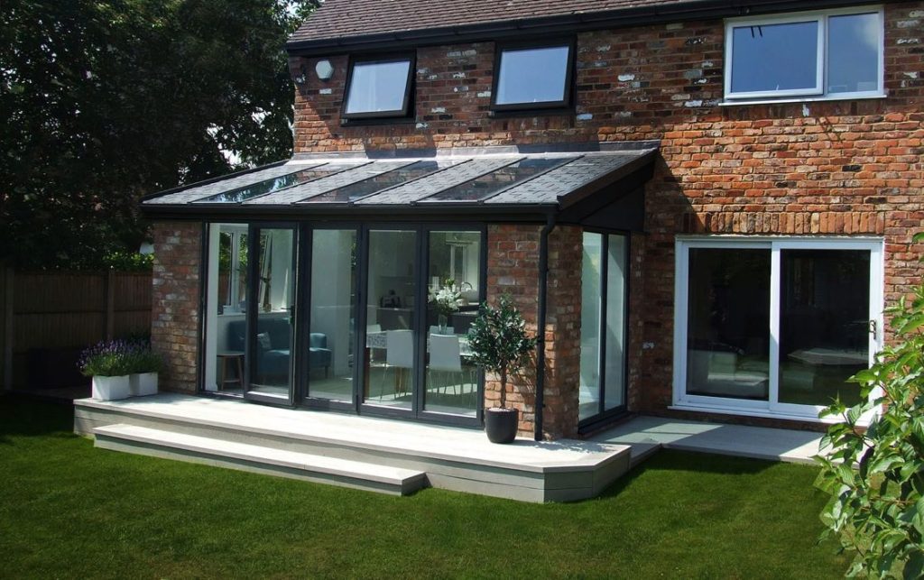 tiled roof extension connected to red brick house with white upvc sliding doors to the side