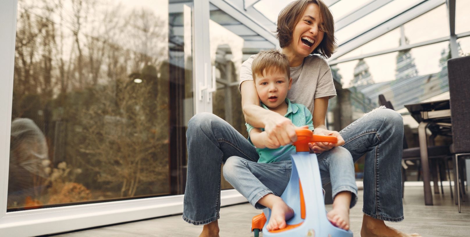 stock image of woman and child playing in conservatory with white upvc sliding doors in the background
